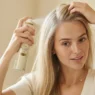 Woman with fine straight hair applying texturizing spray to crown before styling a bandana look