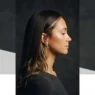 Woman with long Y2K-style hair featuring face-framing highlighted pieces and loose wave ends in amber studio light